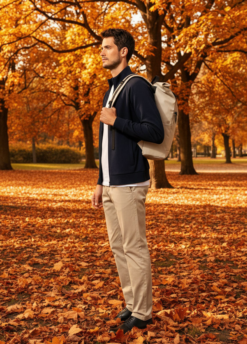 VIVID Rucksack beige – Herren mit navy Zip-Sweatshirt und beiger Chino im herbstlichen Stadtpark