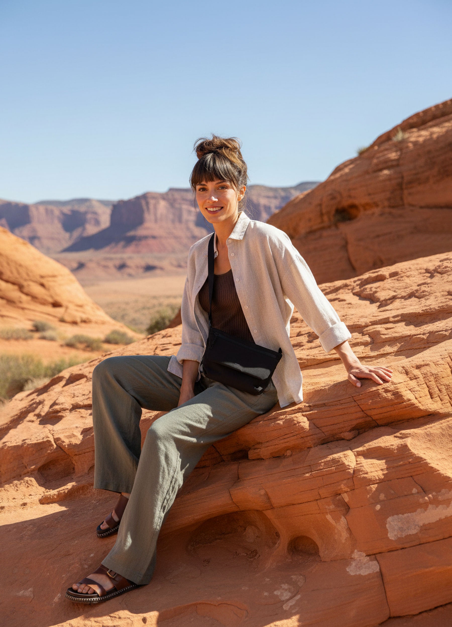 Frau mit schwarzer Tote Bag lehnt an Felsen im Desert Canyon