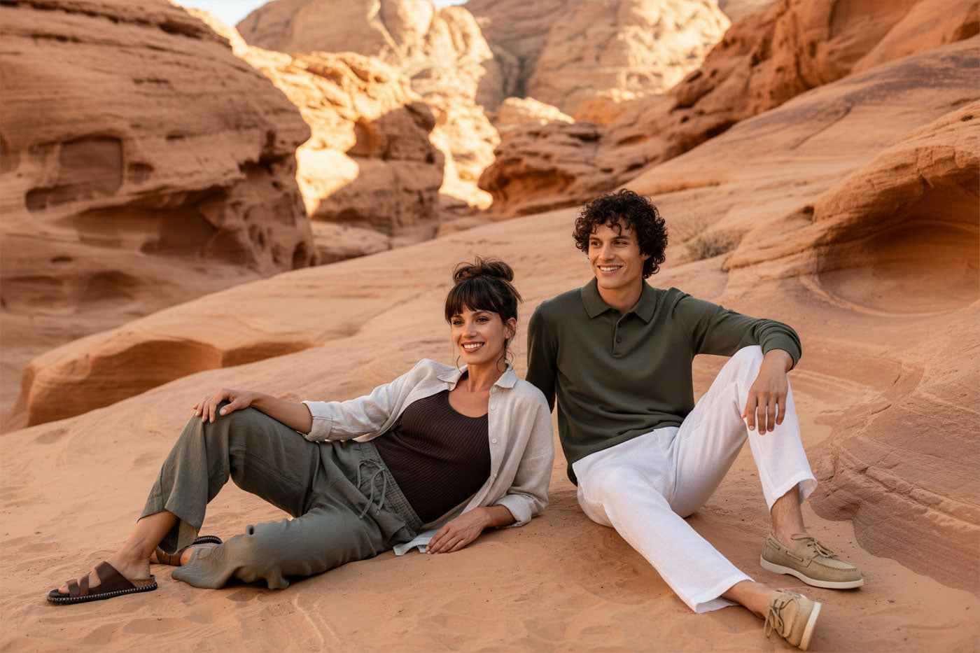 VIVID – Paar in Olive Leinenhose und dunkelgrünem Polo entspannt im Desert Rock Canyon bei Sonnenuntergang