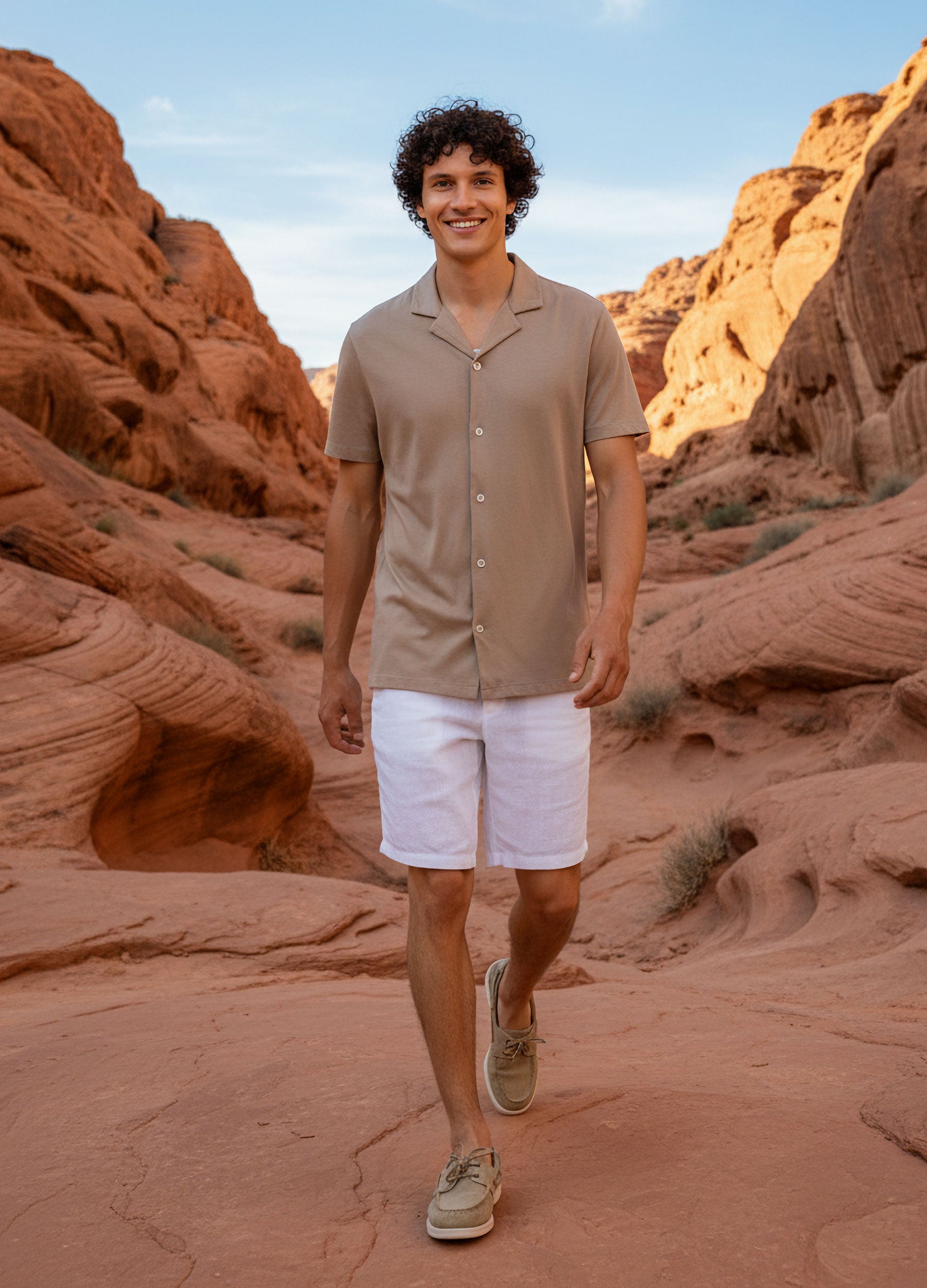 VIVID - Herr in Beigen Polohemd und weißer Leinenshorts gehend im Canyon