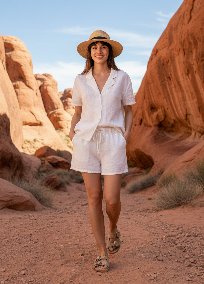 VIVID – Dame in weißem Leinenset mit Strohhut und Sandalen gehend im Desert Rock Canyon