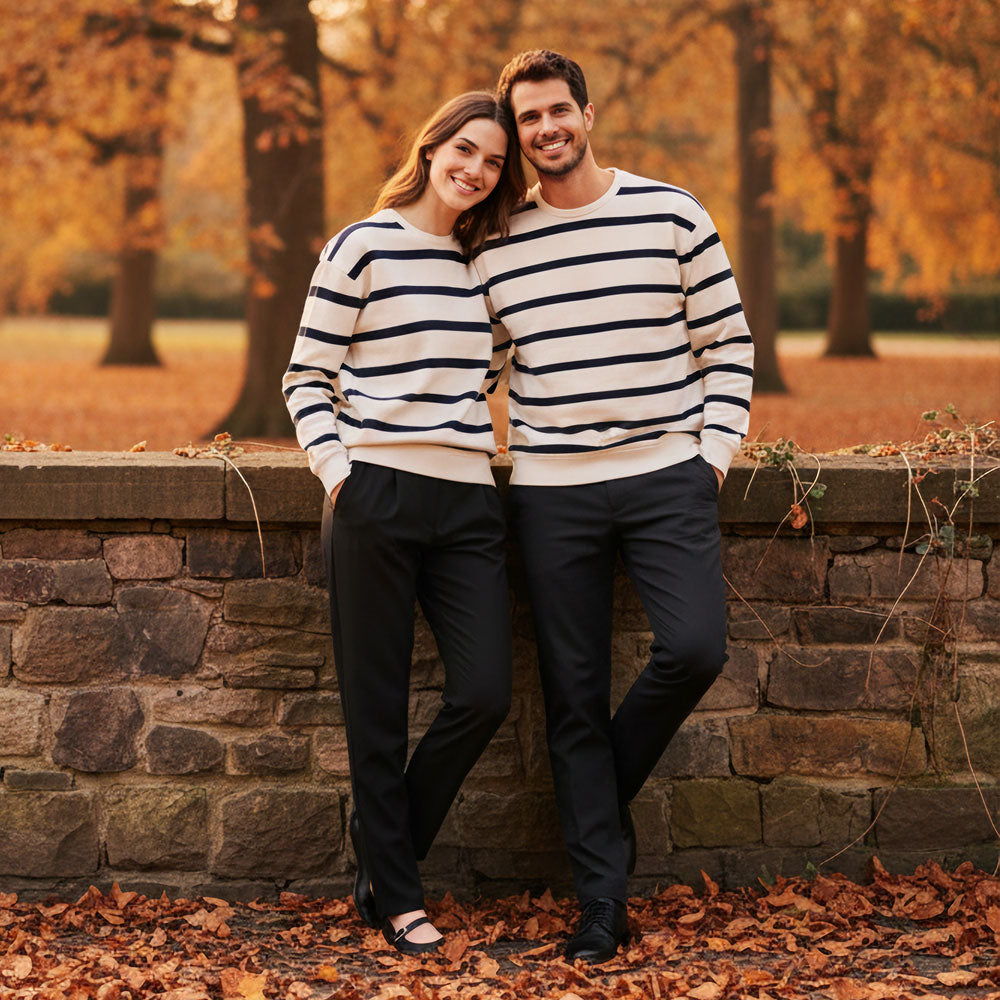 VIVID Marineshirt Damen und Herren creme-navy – Lachendes Paar an Steinmauer mit schwarzer Hose im herbstlichen Stadtpark