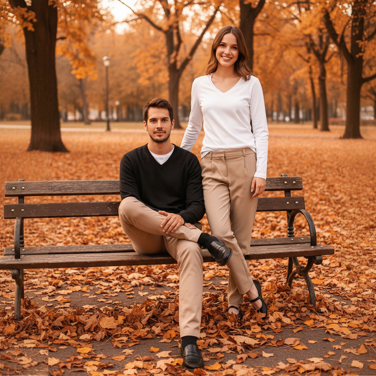 VIVID V-Neck Longsleeve Damen weiß und Herren schwarz – Paar-Outfit mit beiger Hose auf Parkbank im herbstlichen Stadtpark